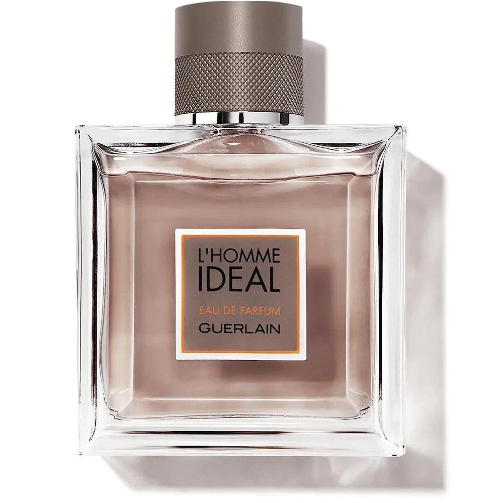 Vierkante fles. Opschrift: L'Homme Ideal, Eau de Parfum, Guerlain. Roze vloeistof, grijze dop. Vierkante vorm.