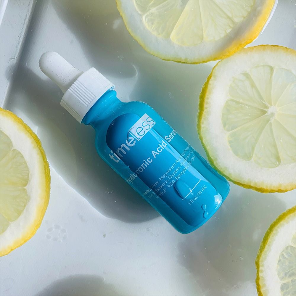 Turquoise fles serum en citroenen. Opschrift: Timeless Hyaluronic Acid Serum. 1 fl oz (30 ml).