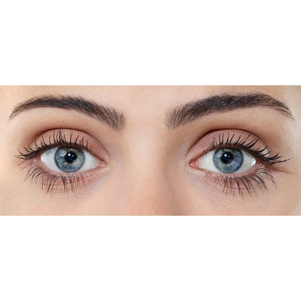 Close-up van twee ogen met mascara. Blauwe ogen, donkere wimpers, wenkbrauwen.