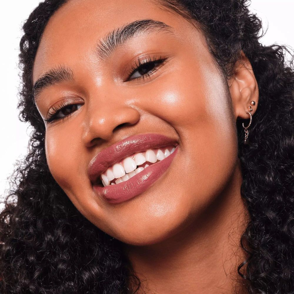 Gros plan d'un visage souriant avec du rouge à lèvres. Rouge à lèvres foncé.