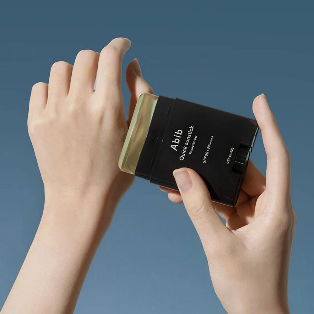 Mains tenant le ABIB Quick Sunstick Protection Bar sur une main.