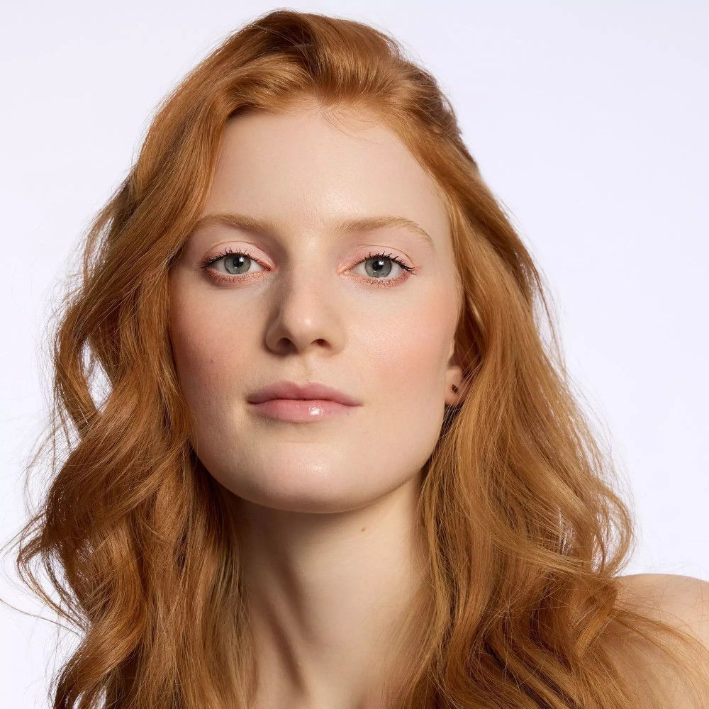 Portrait d'une femme aux cheveux roux. Elle a la peau claire et les yeux bleus. Elle ne porte pas de maquillage.