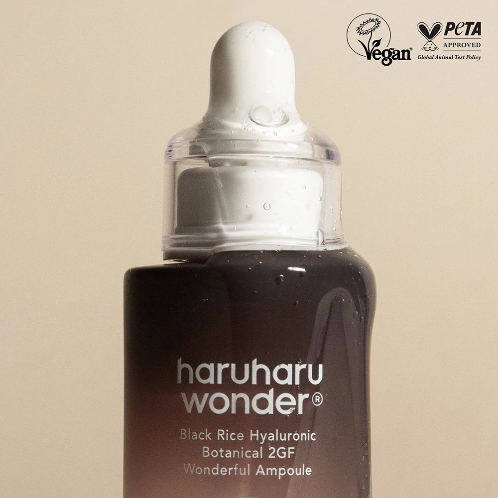 Close-up van serumfles met pipet. Vegan- en PETA-zegels. Opschrift: haruharu wonder, Black Rice Hyaluronic.