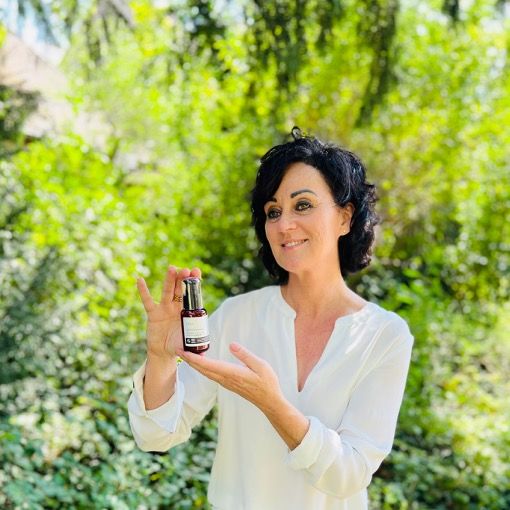 Femme tenant un flacon de produit. Texte: Intense Collagen Booster Serum. Logos: Vegan, IFC Cosmos Organic, Animal Test-Free.