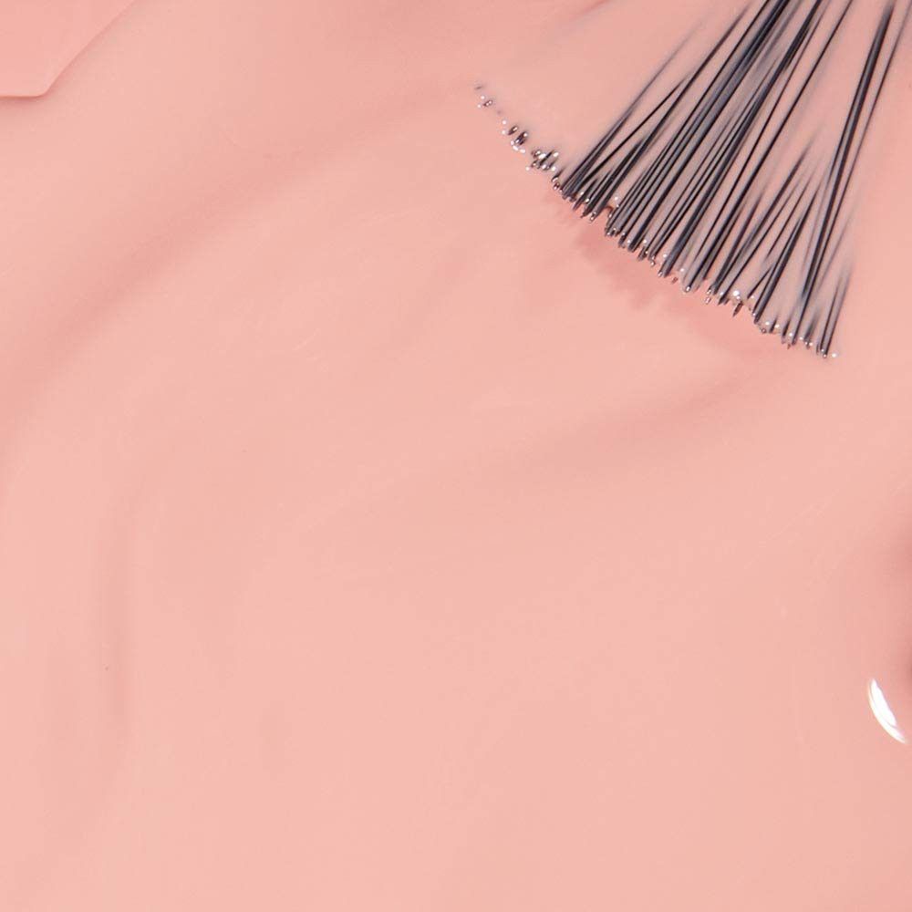 Lichtroze nagellak met penseel. De penseel raakt het gladde, romige oppervlak van de lak.