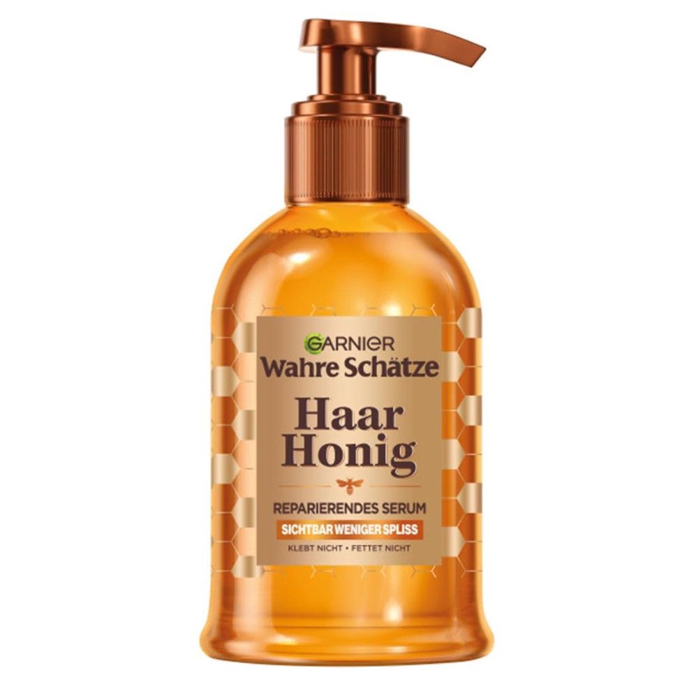 Garnier Trésors de Miel Sérum Cheveux. Flacon transparent avec bouchon et pompe marron. Moins de pointes fourchues visibles.