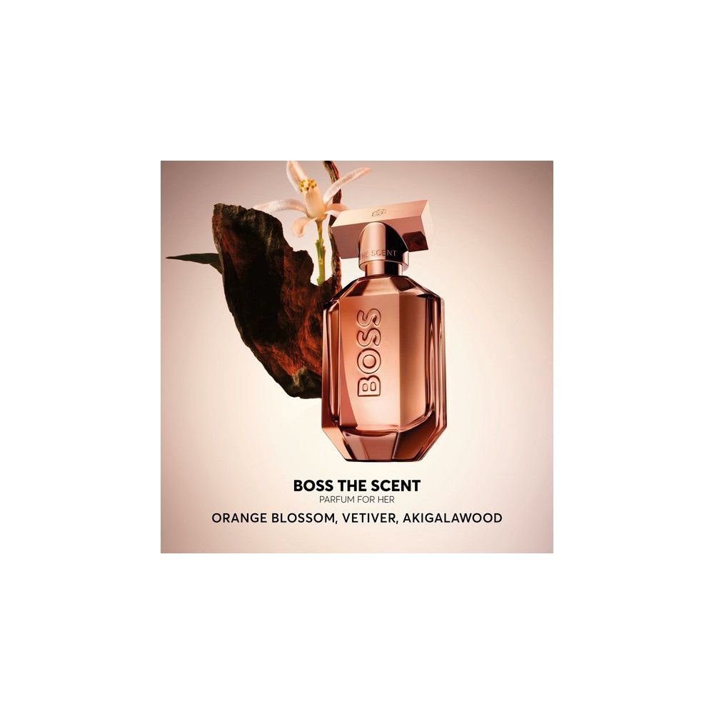 Parfumfles met bloemelementen. Roze fles met gouden dop. Tekst: BOSS THE SCENT PARFUM FOR HER.