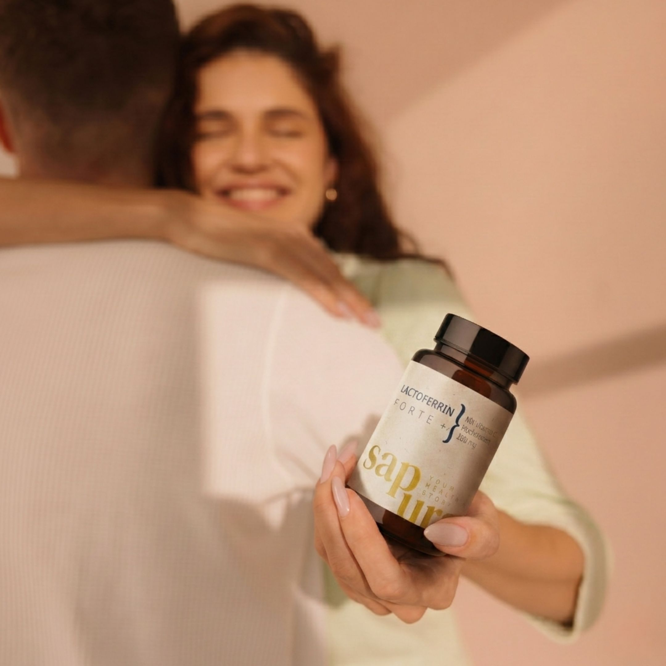 Femme tenant une bouteille de Lactoferrin Forte. Sapura Health.