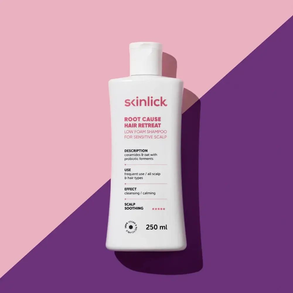 Witte SKINLICK shampoo fles. Roze tekst: ROOT CAUSE HAIR RETREAT. Tekst: LOW FOAM SHAMPOO FOR SENSITIVE SCALP. 250 ml. Vegan.