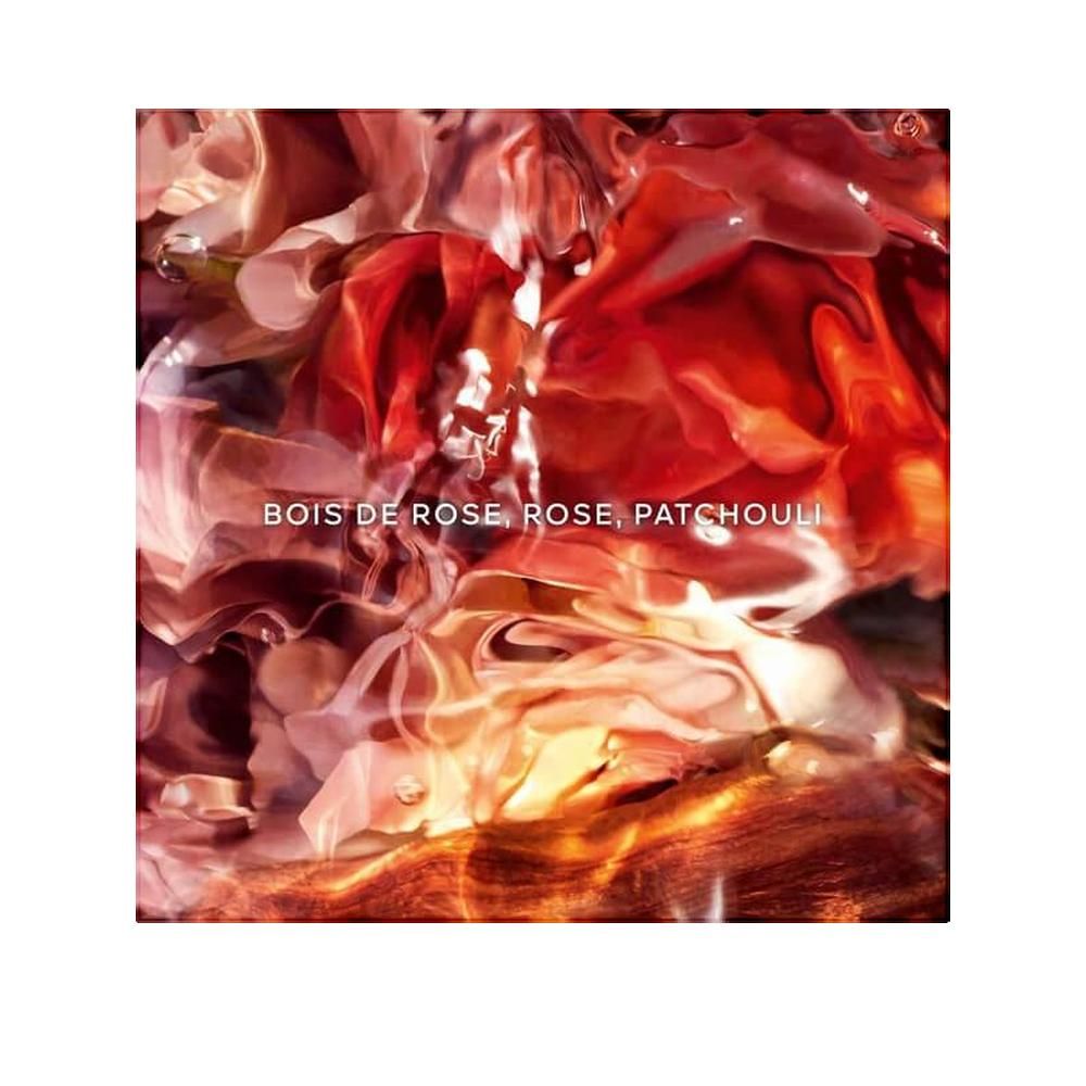 Abstract close-up van rode en oranje bloemblaadjes. Tekst: Bois de Rose, Rose, Patchouli.