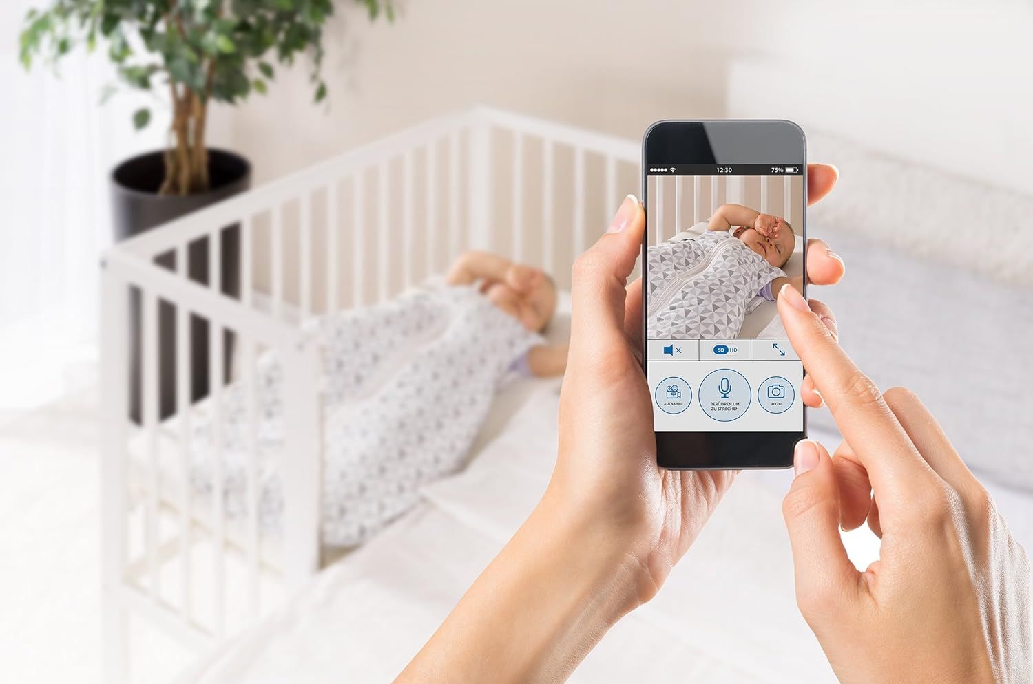Smartphone toont baby in babybedje. Interface met pictogrammen voor functies. Babyfoon niet zichtbaar.