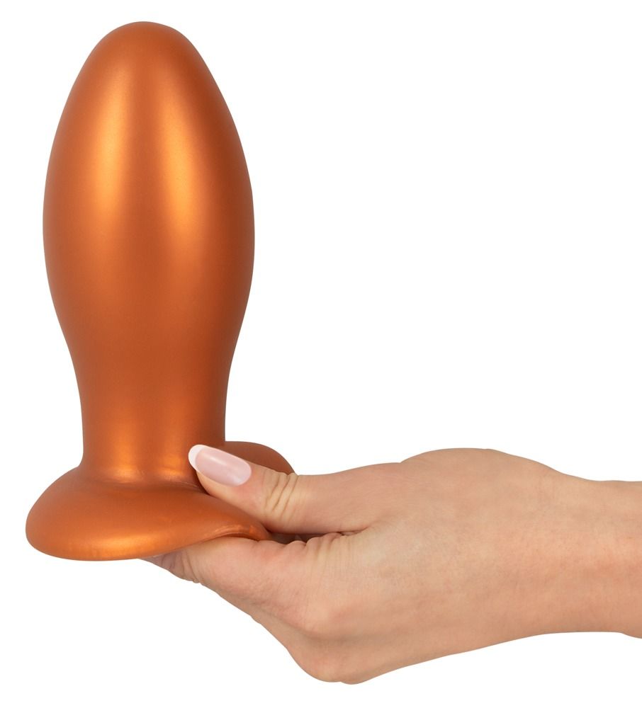 Main tenant un plug anal orange avec ventouse.