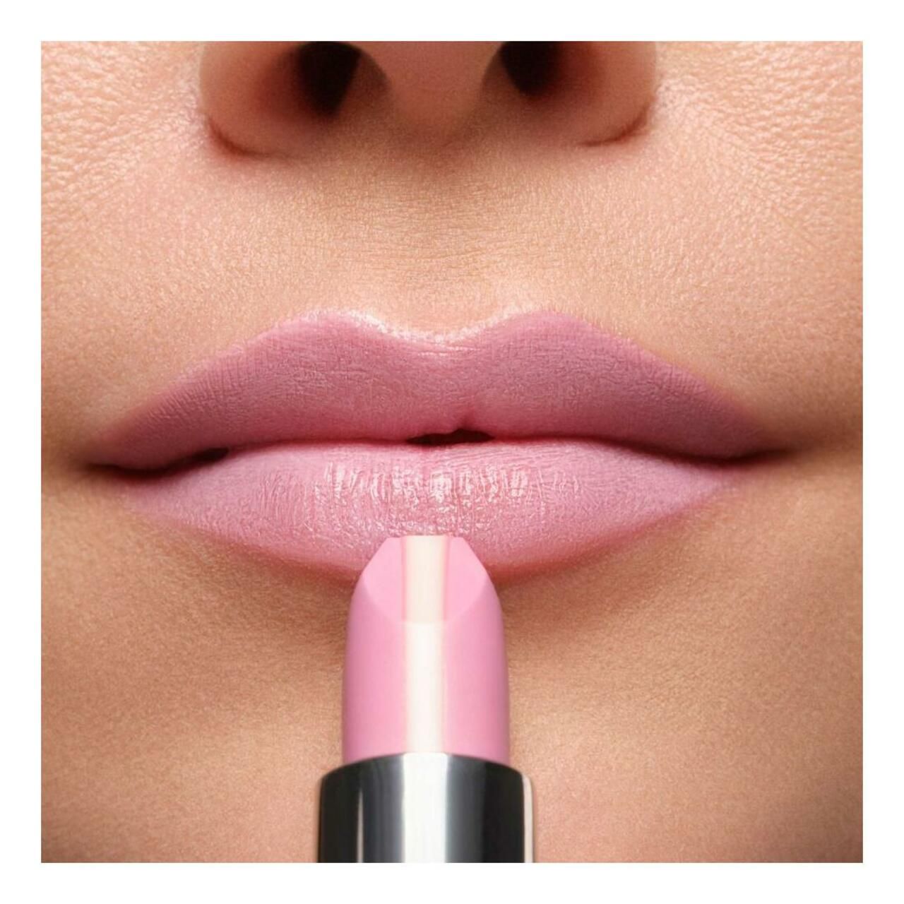 Lippen met roze lipstick. De lipstick heeft een lichte kern. De lipstick wordt op de lippen aangebracht.