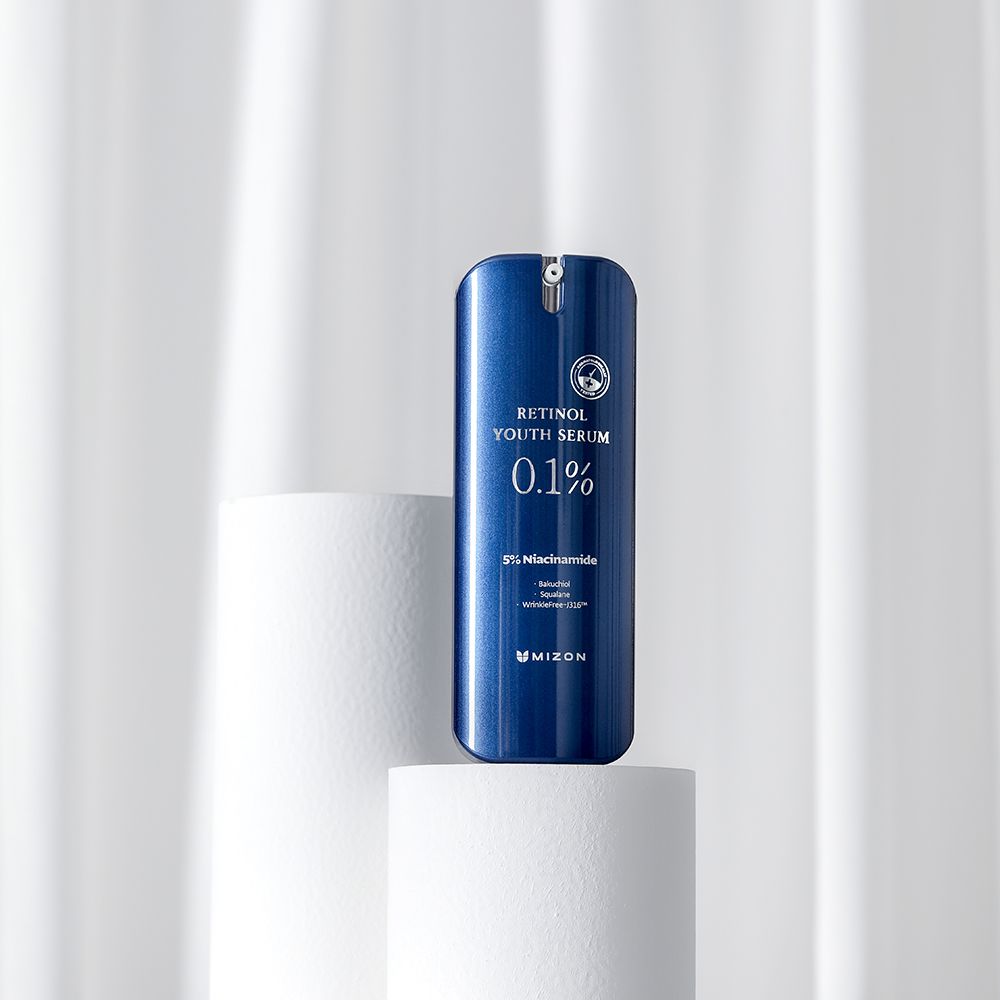 Blauw serum op witte sokkel. Tekst "Retinol Youth Serum 0.1%" en ingrediënten. Merk MIZON.