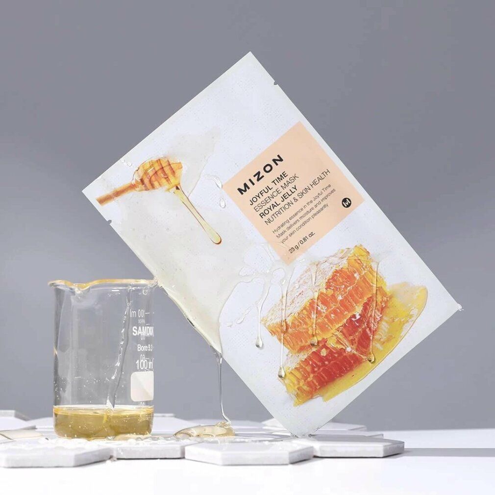 Gezichtsmasker en honingraat. Opschrift: Mizon Joyful Time Essence Mask Royal Jelly. Honing druppelt. Bekerglas.