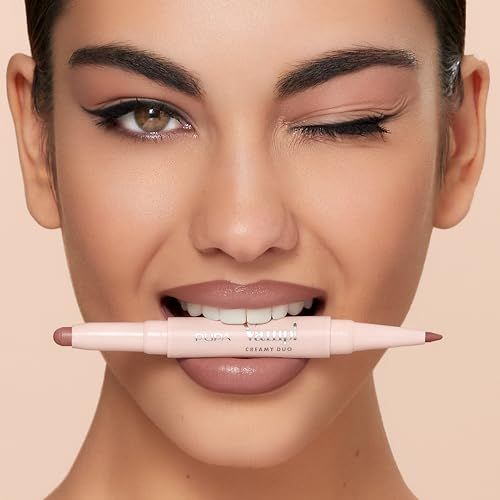 Vrouw met lippenstift in haar tanden. Dubbele pen met opschrift Pupa Milano Vamp! Creamy Duo.
