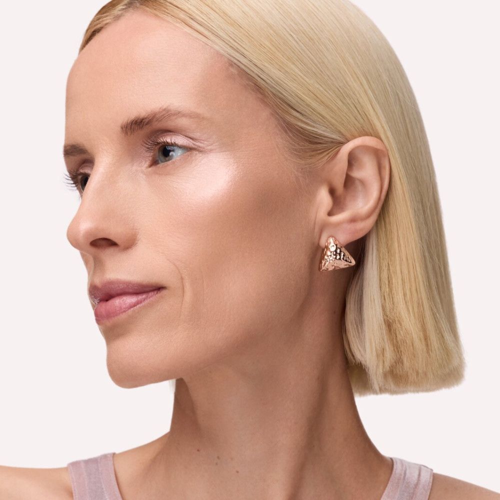 Portrait d'une femme blonde. Enlumineur sur les pommettes. Boucles d'oreilles dorées.