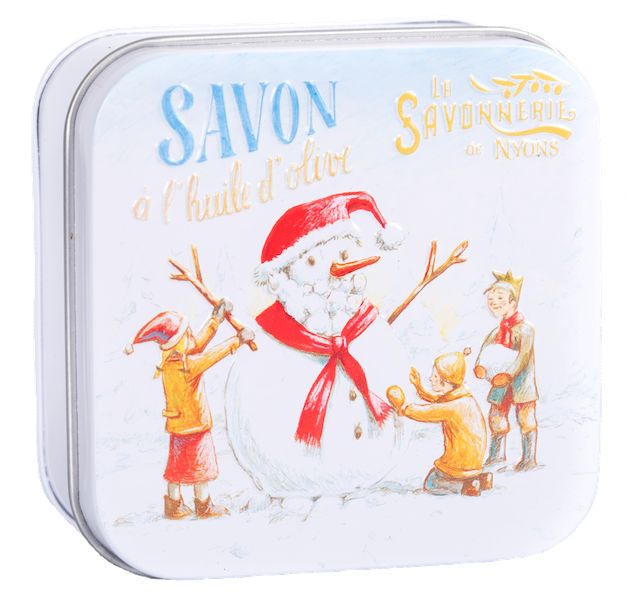 Boîte métallique fermée avec illustration de bonhomme de neige et texte "Savon à l'huile d'olive".