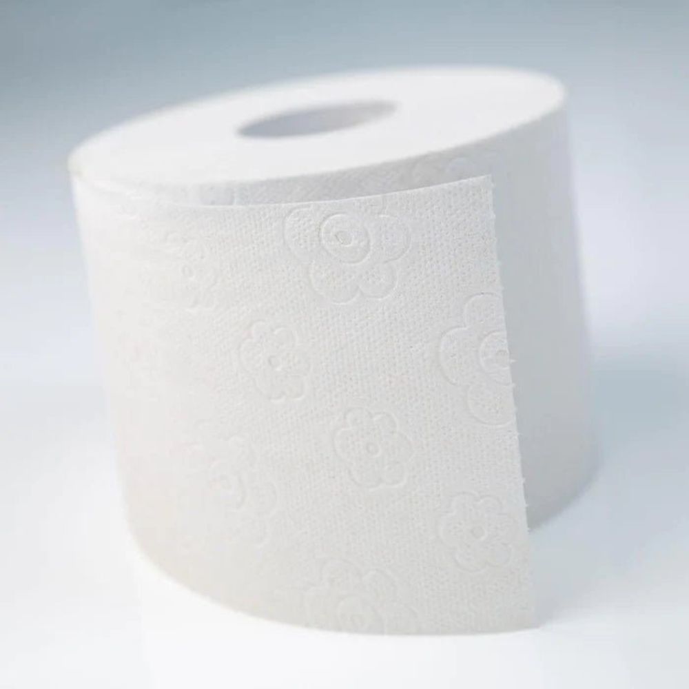 Witte toiletpapierrol met bloemmotief, gedeeltelijk afgerold.