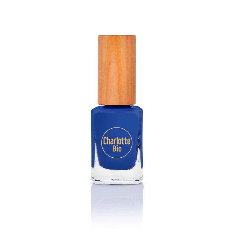 Blauwe nagellakfles met houten dop. Het logo "Charlotte Bio" is zichtbaar.