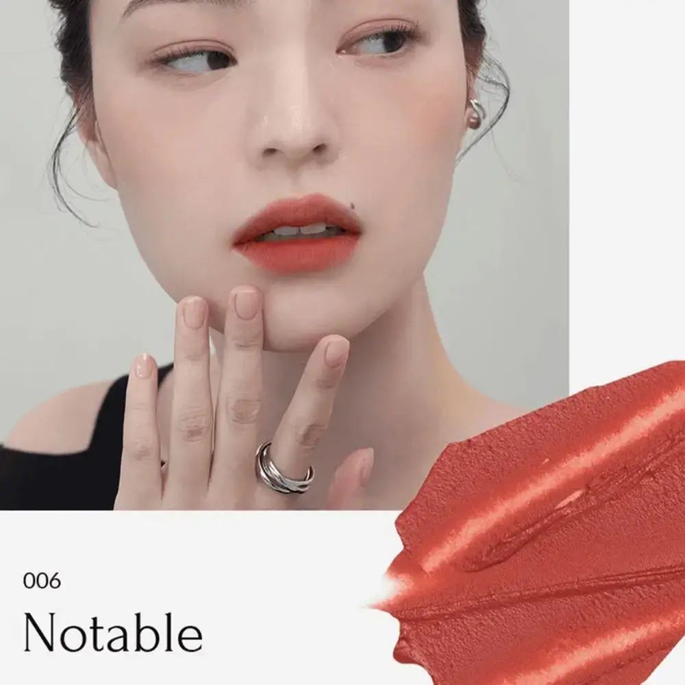 Vrouw met lippenstift. Kleur: 006 Notable. Tint op lippen en veeg. Ring om vinger. Lichte huidskleur.