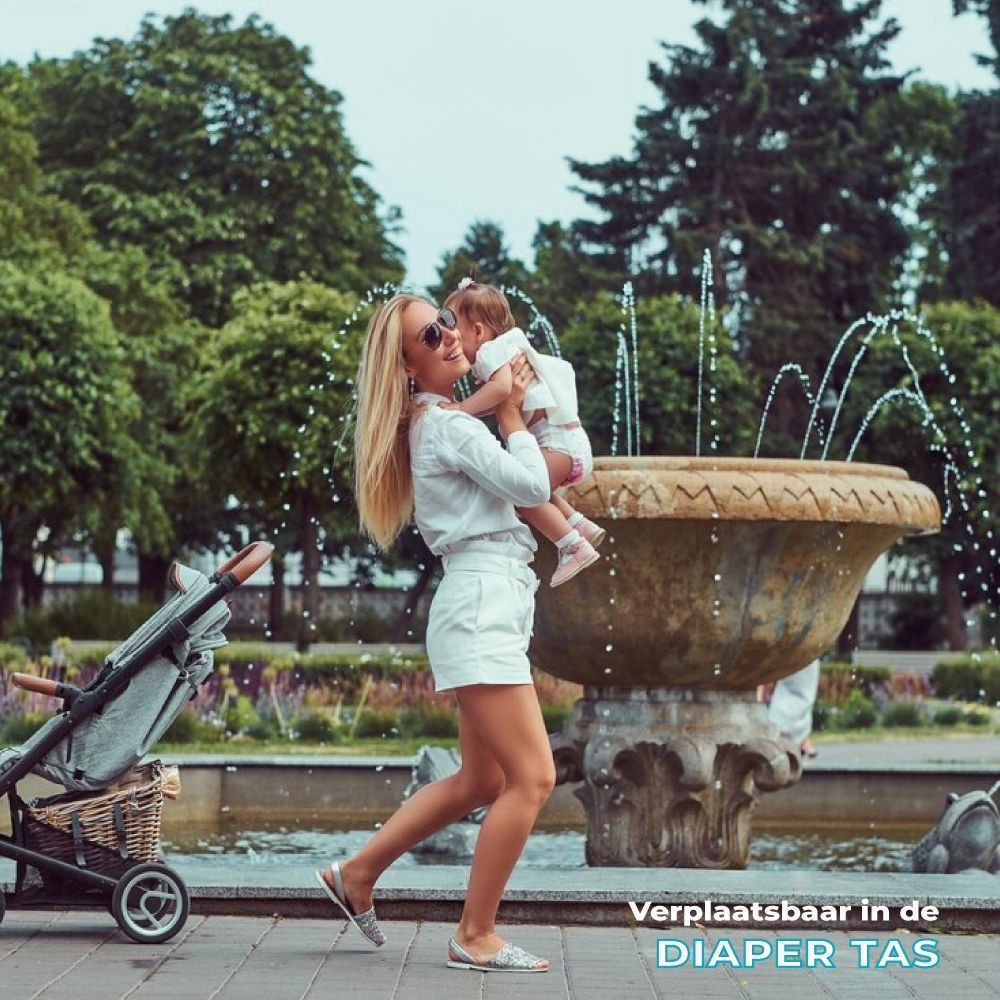Vrouw met baby in park. Baby in kinderwagen. Tekst: Verplaatsbaar in de luiertas.