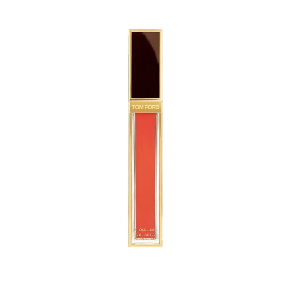 Gloss à lèvres rouge intense dans un étui rectangulaire transparent. Capuchon doré. Contenu rouge visible, nom de la marque.