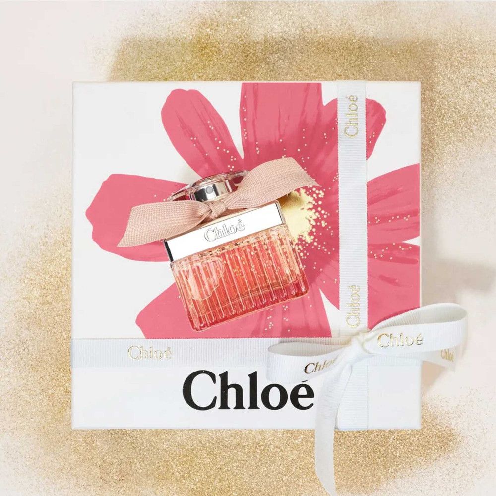 Geschenkdoos met roze bloem en strik. Flesje met strik. Opschrift Chloé op doos en strik.