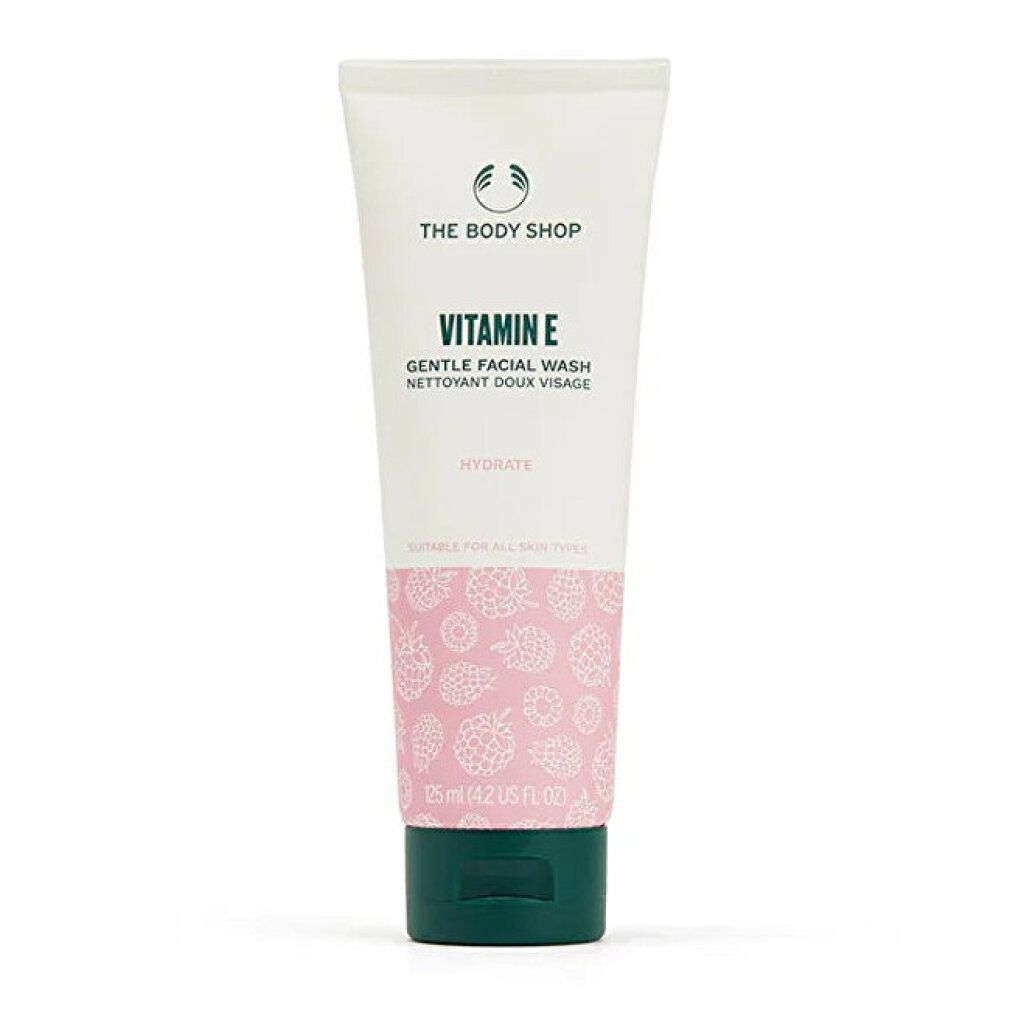 Tube The Body Shop Vitamin E Gentle Facial Wash, 125 ml. Tube blanche avec motif rose et bouchon vert.
