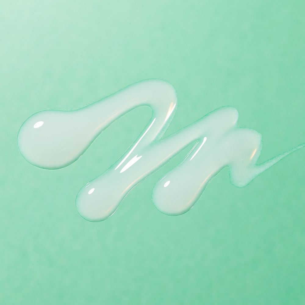 Gouttes de sérum sur fond vert. Liquide disposé en lignes ondulées.