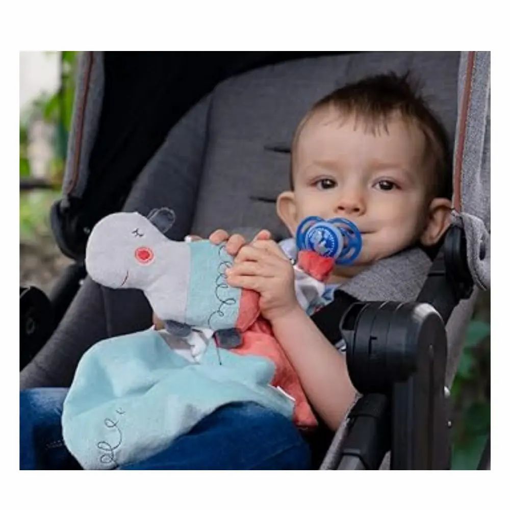 Enfant dans une poussette avec doudou et tétine. Tête d'hippopotame, tissu bleu.