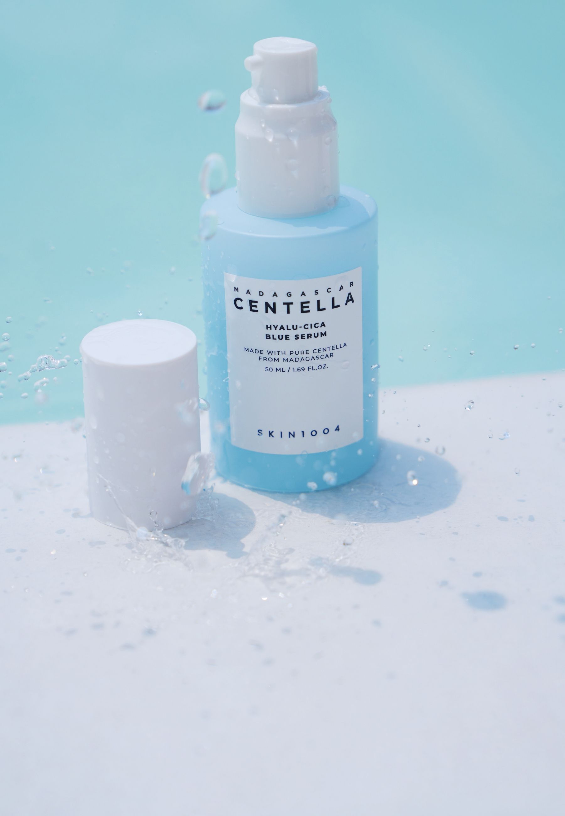 Serumfles met spatten. Opschrift: MADAGASCAR CENTELLA HYALU-CICA BLUE SERUM. Merk: SKIN1004. Fles en dop.