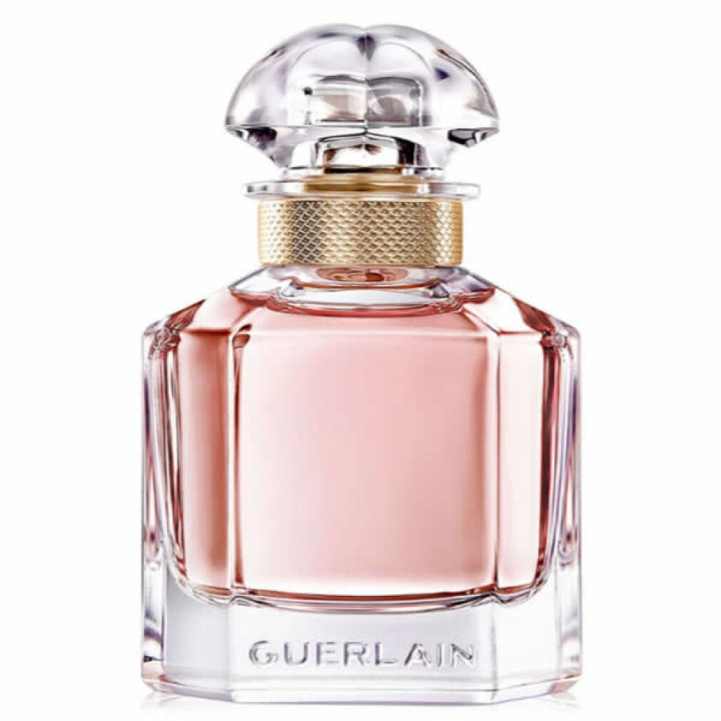 Flacon de parfum carré avec liquide rose, bouchon doré et couvercle transparent. Forme géométrique.