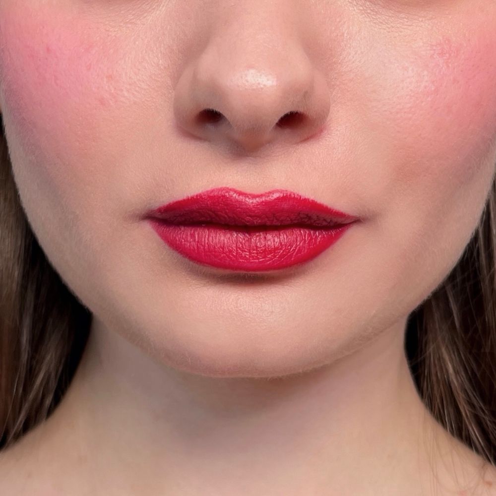 Gros plan sur des lèvres avec du rouge à lèvres rouge et des joues rougies. Teint.