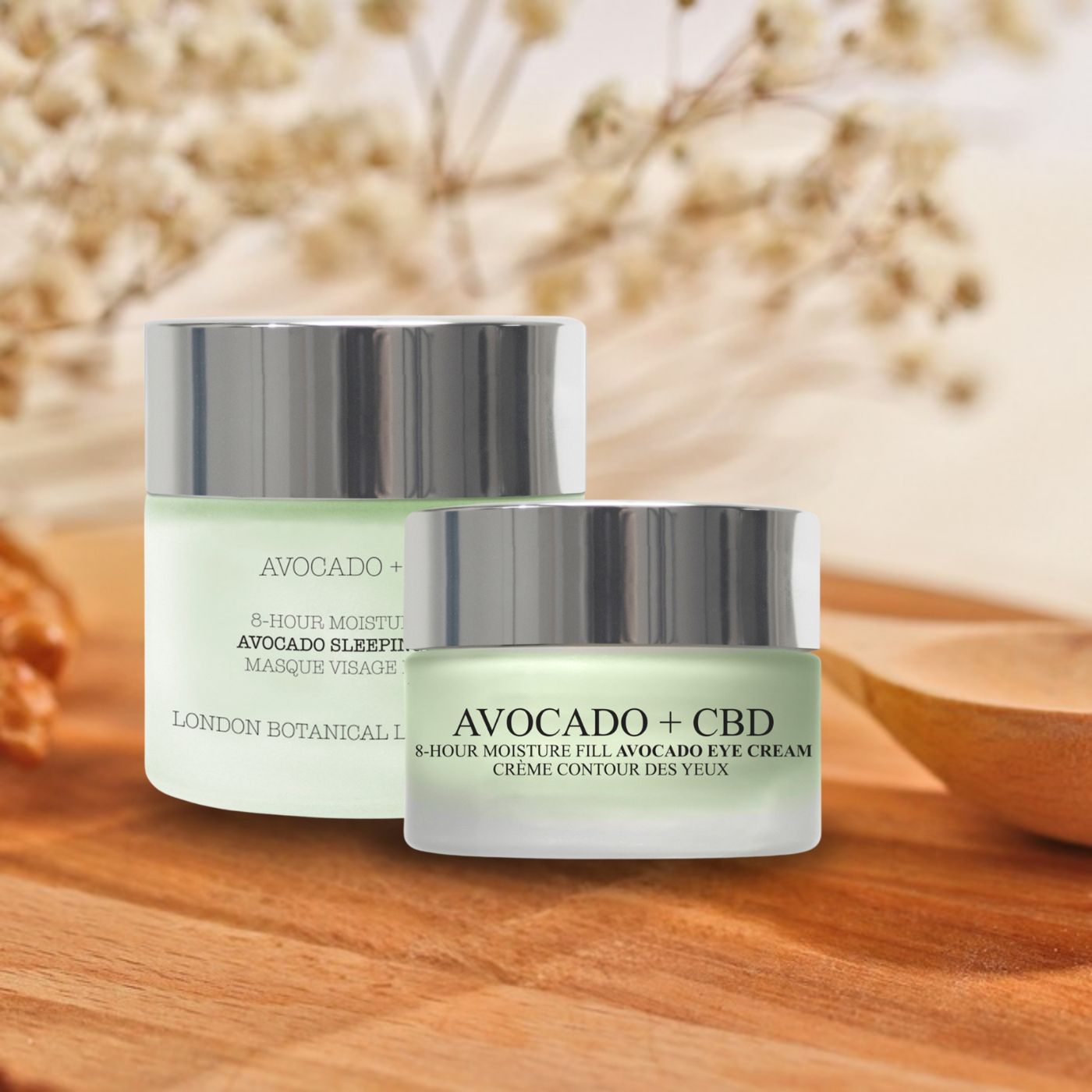 Deux pots en verre avec couvercles argentés. Texte : Avocado + CBD, Avocado Sleeping Mask et Eye Cream. Sur fond bois.
