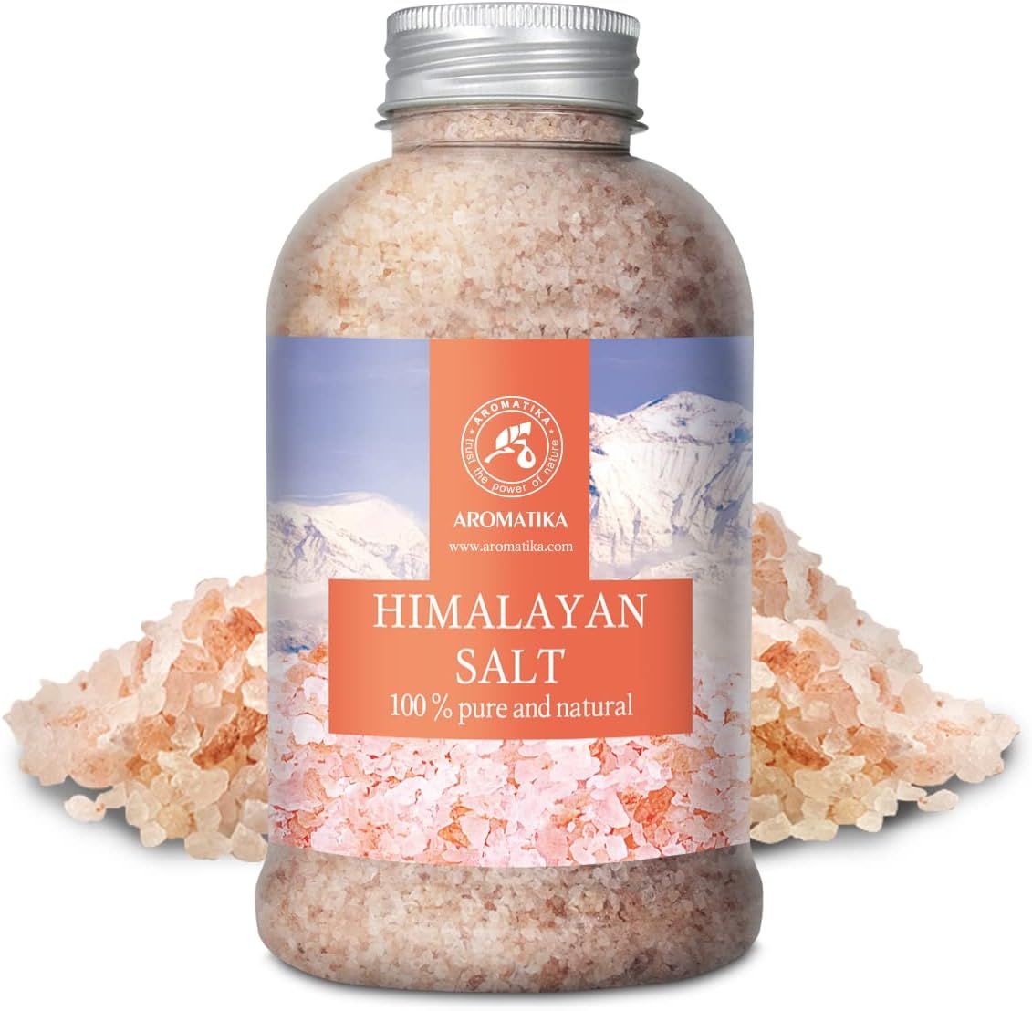 Bouteille de sel rose de l'Himalaya, entourée de cristaux de sel. Étiquette avec montagnes et "HIMALAYAN SALT".
