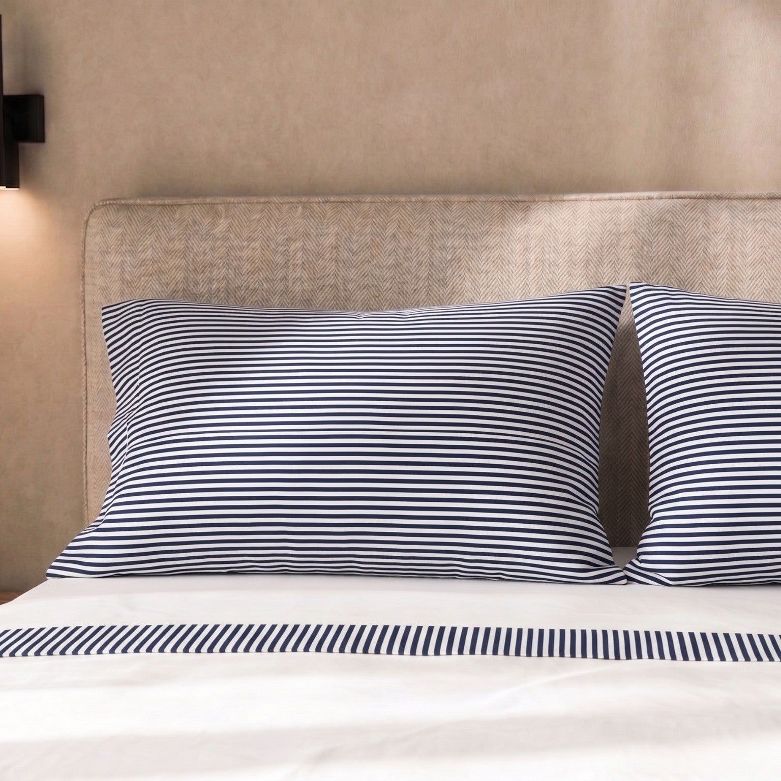 Kussenslopen met blauw-witte strepen op een bed.