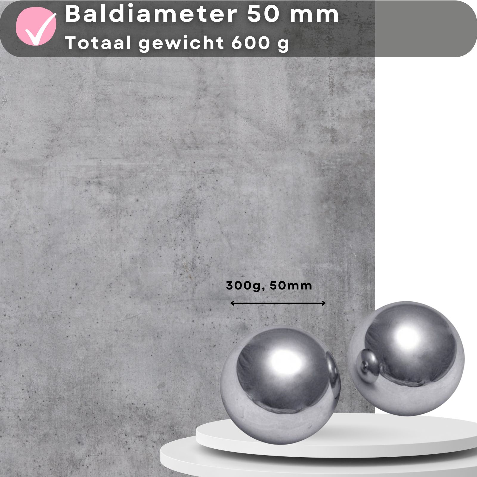 Twee metalen ballen op een platform. Tekst: 50mm, 600g. Achtergrond: betonnen muur.