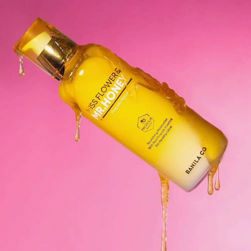 Geel-witte lotionfles met gouden pomp. Honing druipt over de fles. Opschrift: Miss Flower & Mr. Honey.