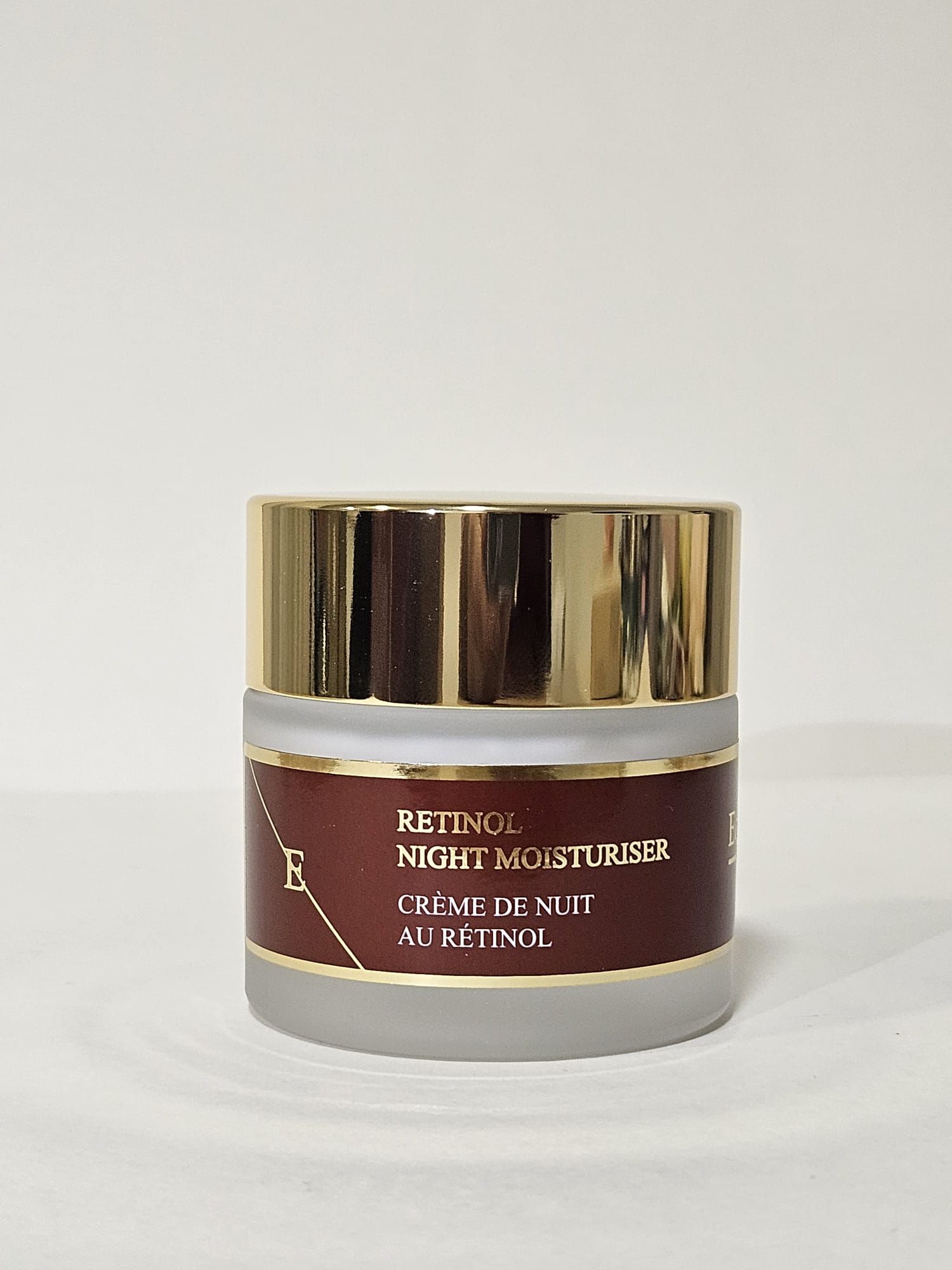 Crème hydratante de nuit au rétinol dans un pot en verre avec couvercle doré. Étiquette rouge. ErthSkin London.