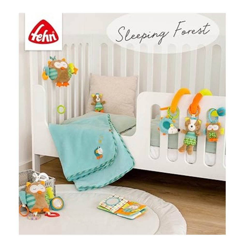 Babyspeelgoedset met stoffen boek en knuffels. Merk: fehn. Op een wit kinderbed. Op de achtergrond: speelgoed en decoratie.
