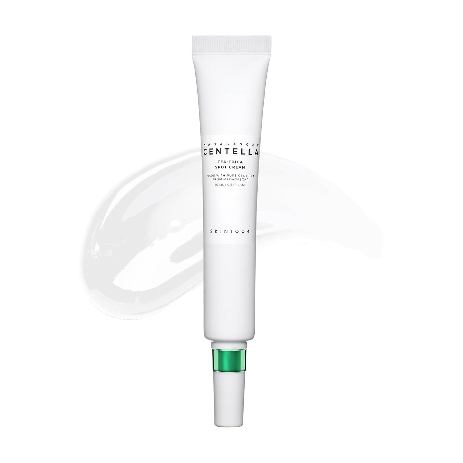 Witte tube met groene dop. Opschrift: Tea-Trica Spot Cream. Op de tube staat SKIN1004. Daarnaast een klodder crème.