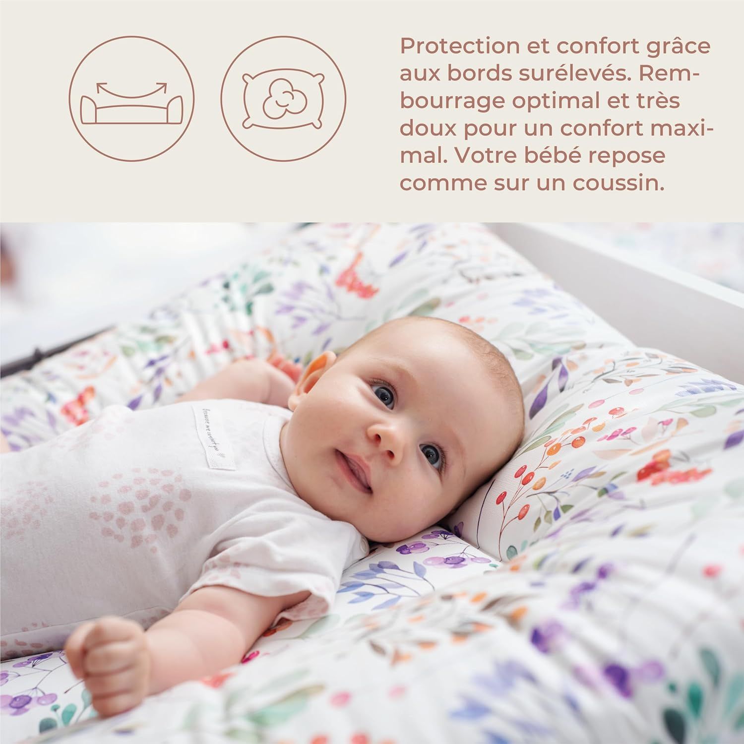 Bébé sur matelas à langer à motifs floraux. Bords surélevés. Texte: 'Protection et confort grâce aux bords surélevés'.