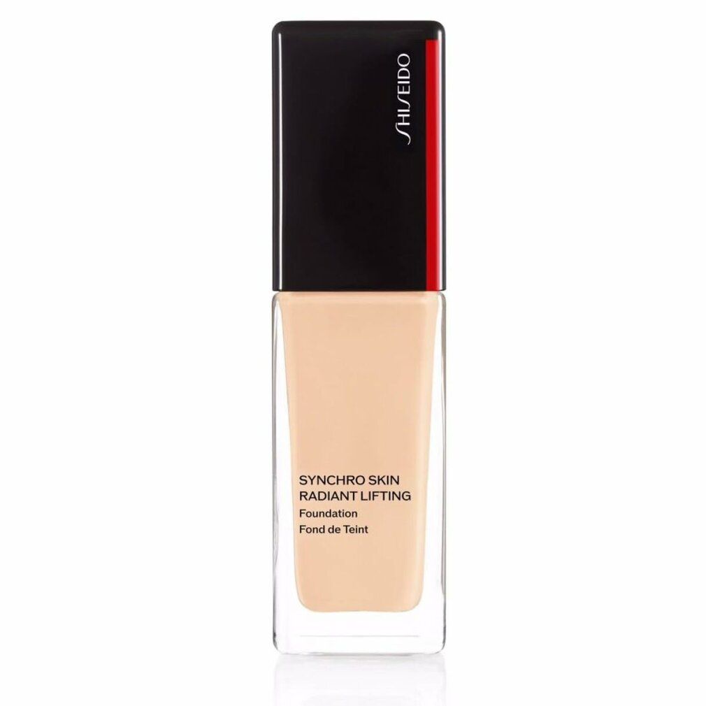 Flacon de fond de teint beige. Bouchon noir avec détail rouge. Inscription: SHISEIDO, SYNCHRO SKIN RADIANT LIFTING Foundation Fond de Teint.
