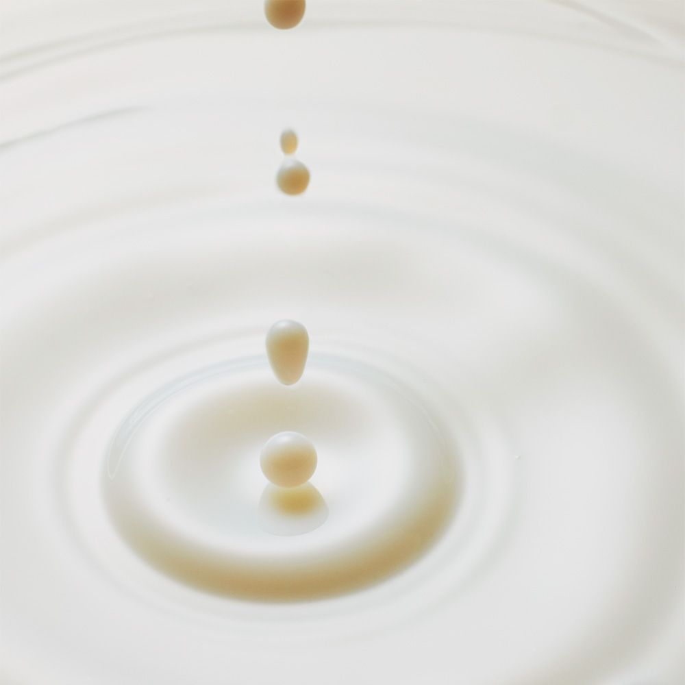 Druppels vallen in een melkachtige vloeistof en creëren concentrische cirkels.