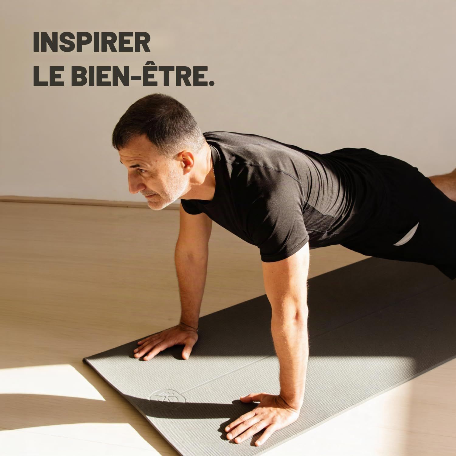 Homme en tenue de sport faisant des pompes sur un tapis de yoga, texte : Inspiring Wellness.