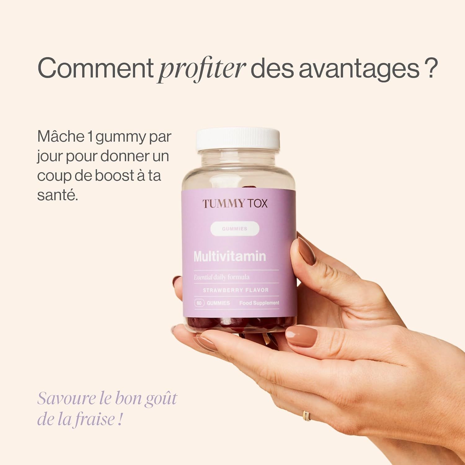 Une main tient une bouteille de gommes Tummy Tox Multivitamines saveur fraise.
