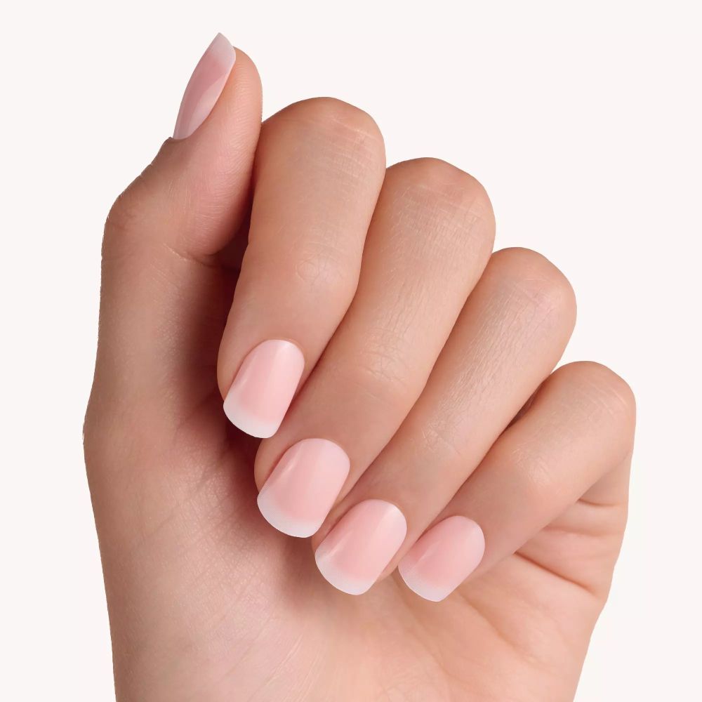 Hand met lichtroze kunstnagels. Natuurlijke uitstraling.