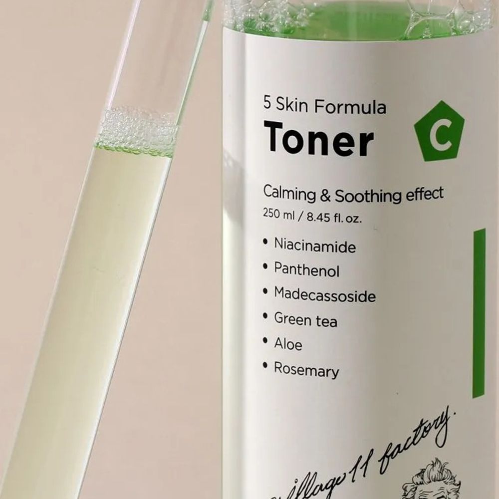 Close-up van een fles met groenige vloeistof en een reageerbuis. Productnaam en ingrediënten op het etiket.