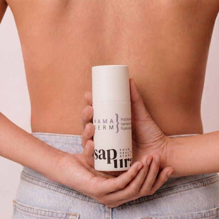 Persoon houdt witte fles met pompdos achter de rug vast.